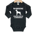 Warning Protected By A Doberman, Doberman Baby Onesie, Doberman Bodysuit, Newborn Doberman Outfit, Doberman Romper, Infant Doberman Onesie - Chase Me Tees LLC